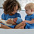 Mixed race siblings look at newborn baby boy or girl